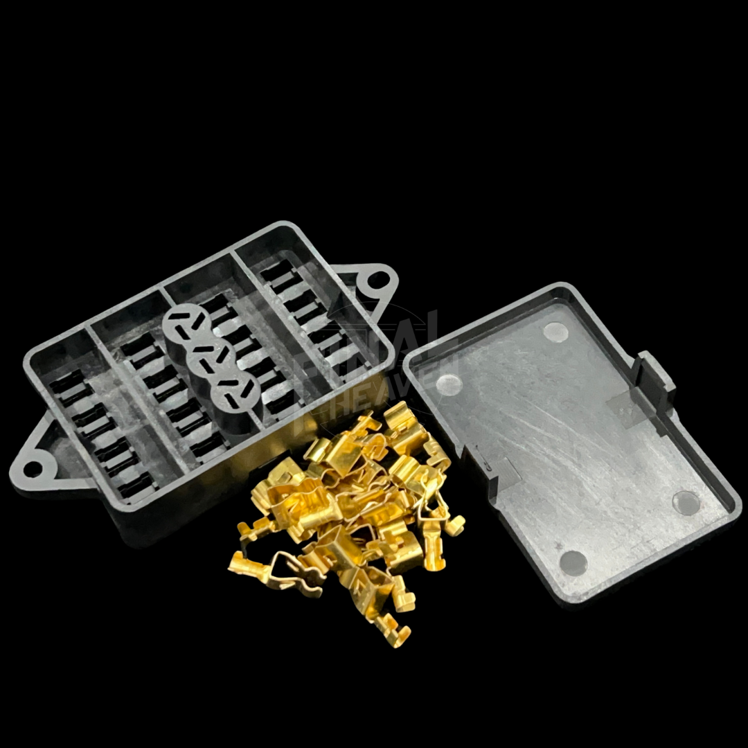 A set of fusebox repair kit components for a NIssan Hakosuka Skyline including a black plastic box, a cover, and gold-colored pins.